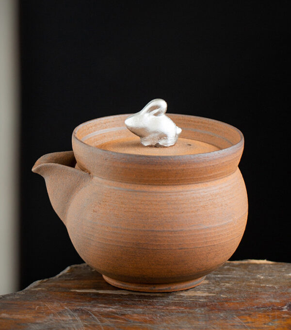Old Rock mud rich rabbit hand holding pot